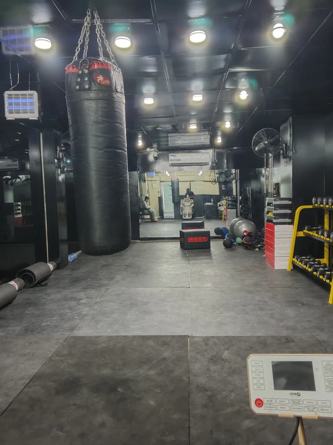 Boxing bag, medicine balls and plyometric boxes across the studio
